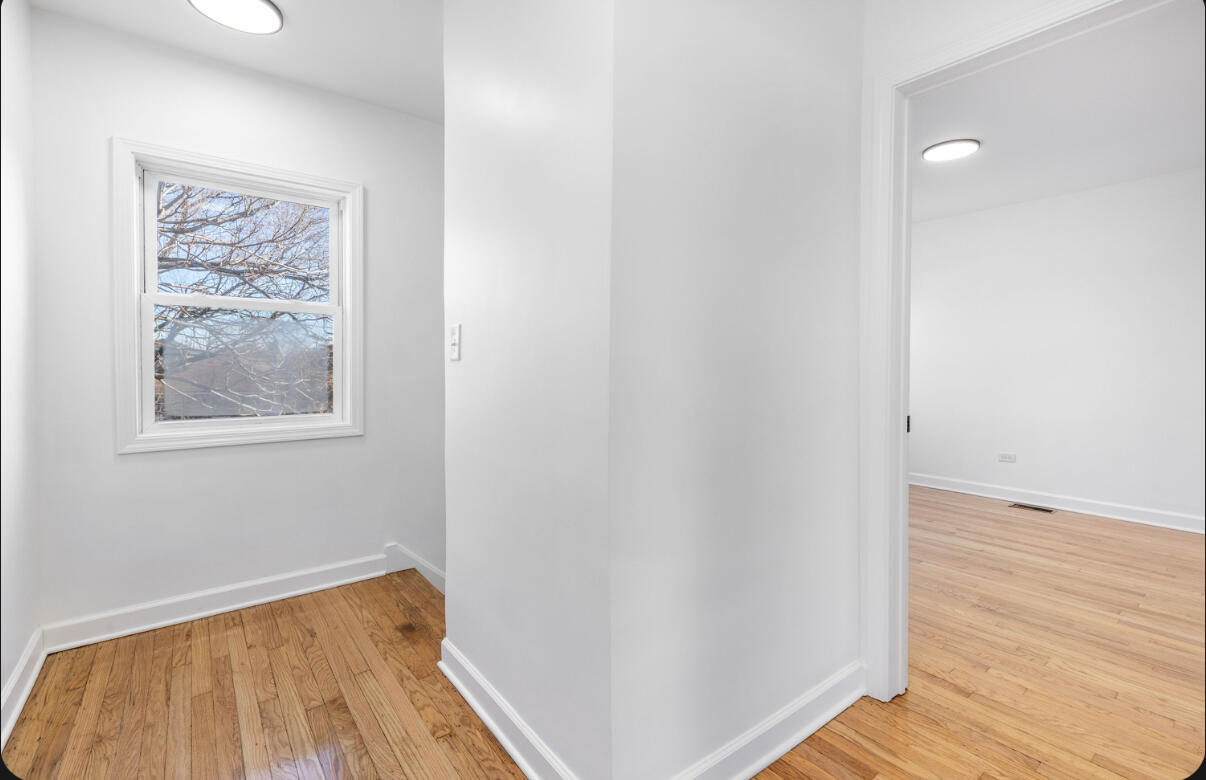 419 Cleveland Street Gary, IN 46404 - Photo 28 of 42 an empty room with wooden floor and windows