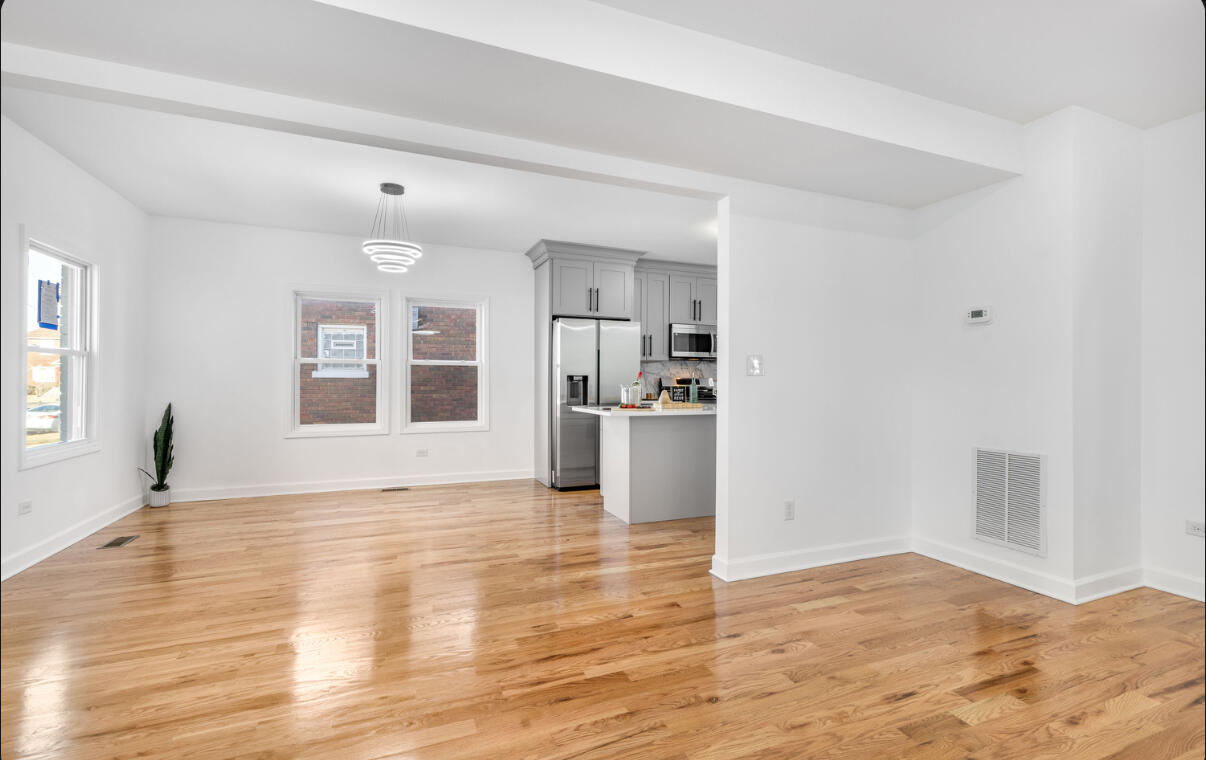 419 Cleveland Street Gary, IN 46404 - Photo 6 of 42 a view of empty room with wooden floor and kitchen