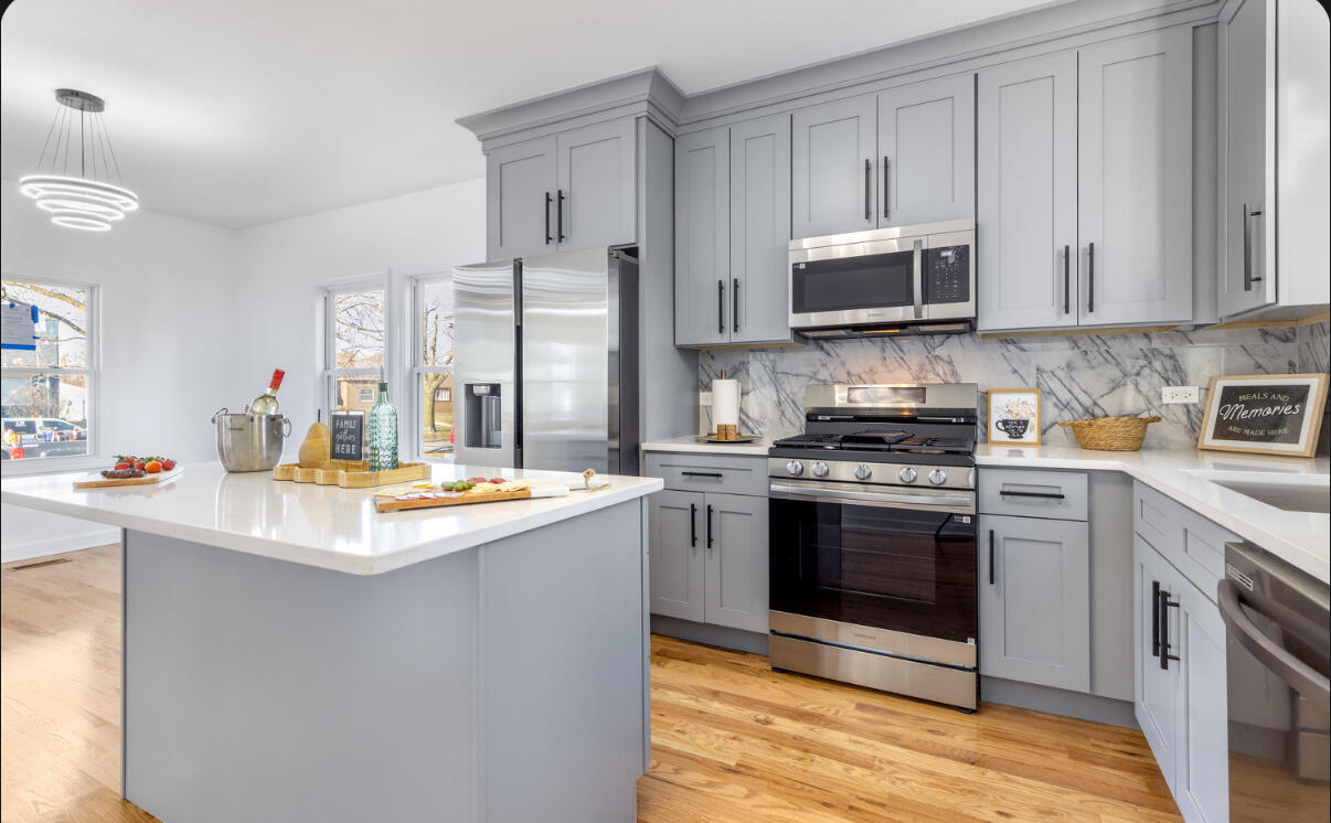 419 Cleveland Street Gary, IN 46404 - Photo 9 of 42 a kitchen with stainless steel appliances granite countertop a stove top oven a sink and white cabinets