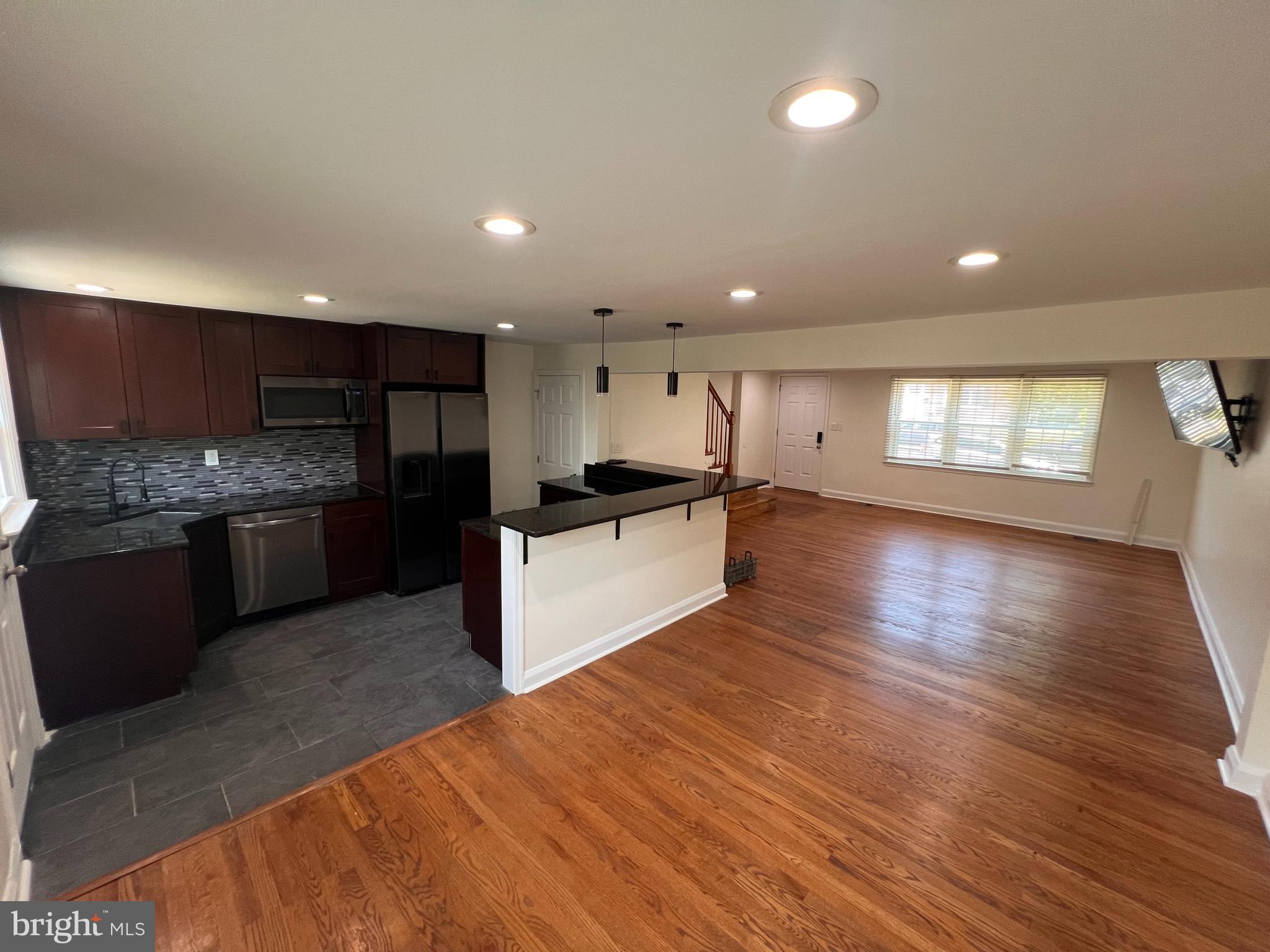 1583 Doxbury Road Towson, MD 21286 - Photo 4 of 31 a large kitchen with stainless steel appliances granite countertop a large counter top and a stove with wooden floor