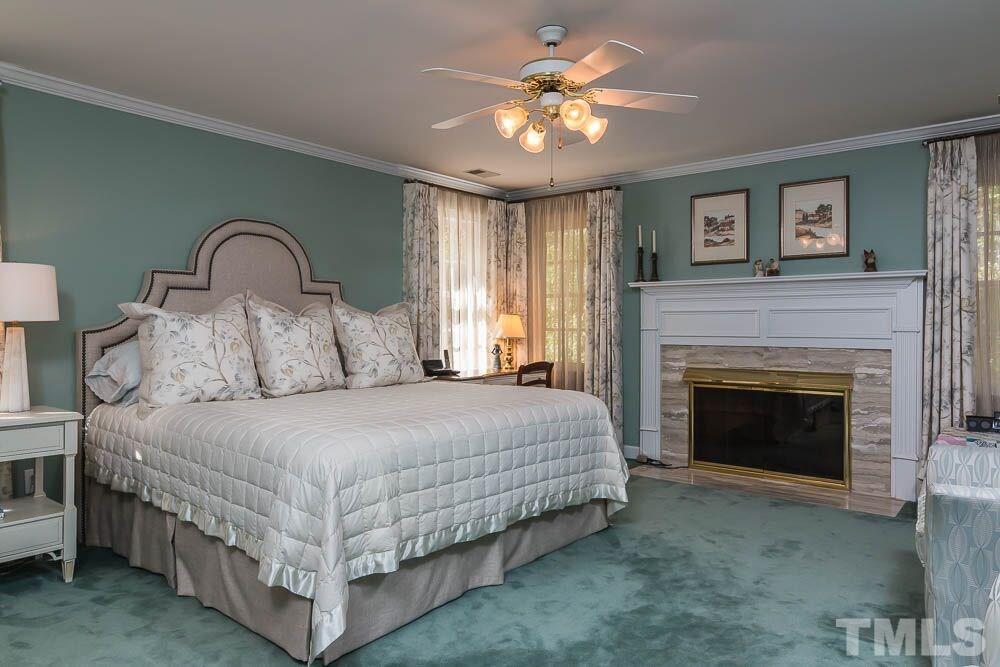 7525 Hazelhurst Circle Apex, NC 27502 - Photo 13 of 25 a bedroom with a bed and a fireplace