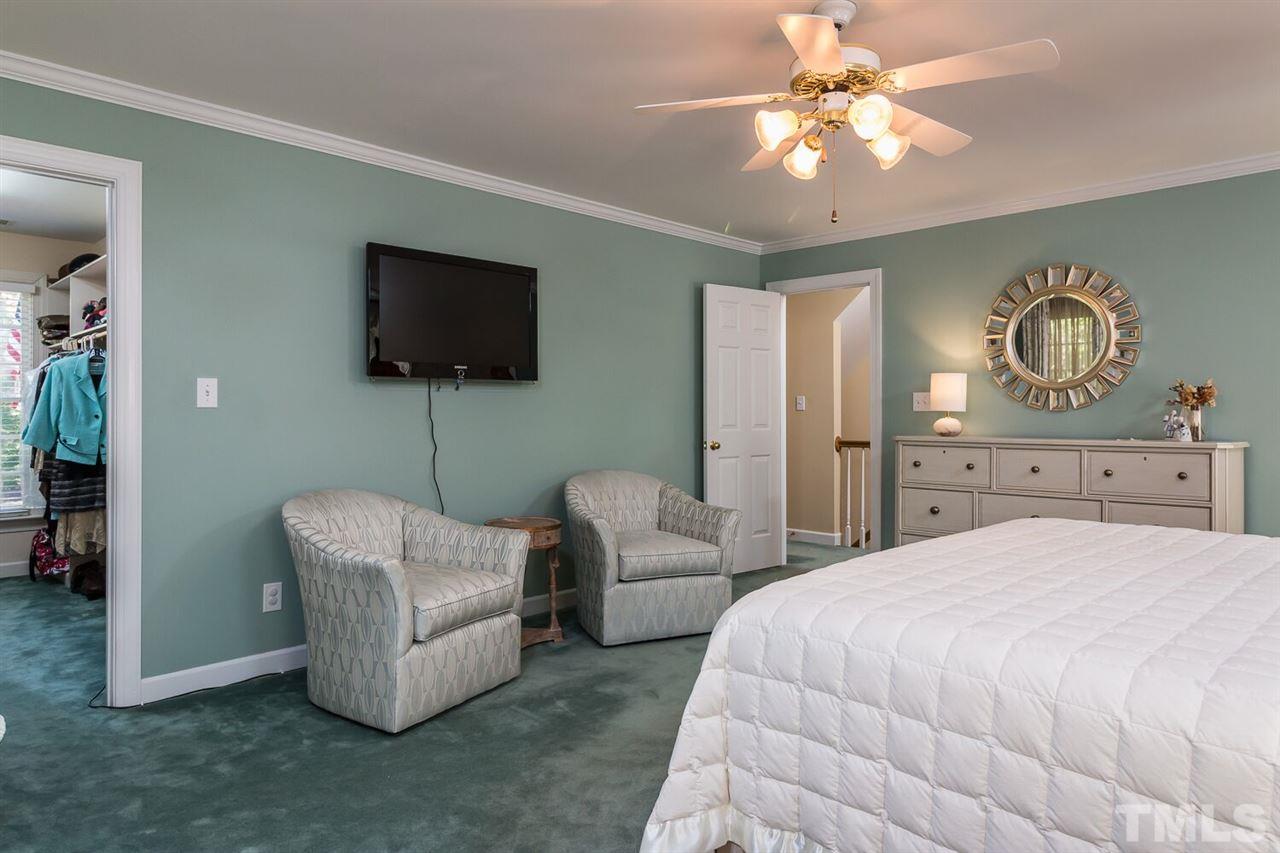 7525 Hazelhurst Circle Apex, NC 27502 - Photo 14 of 25 a bedroom with a bed a couch and a flat screen tv