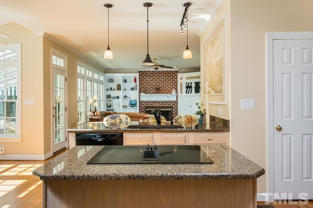 7525 Hazelhurst Circle Apex, NC 27502 - Photo 10 of 25 a living room with kitchen island granite countertop furniture a rug a fireplace and a window
