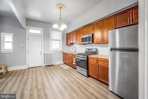 a kitchen with stainless steel appliances granite countertop a refrigerator a stove a sink dishwasher and a refrigerator with wooden floor