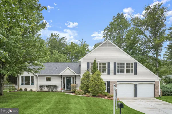 a front view of a house with a yard and trees