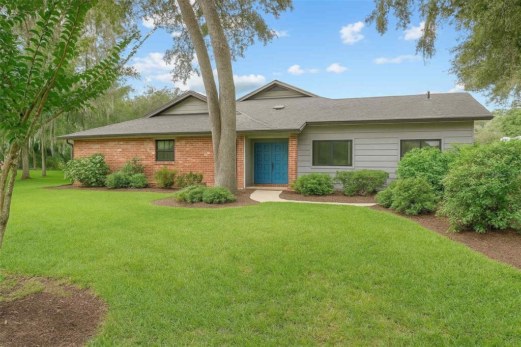 a view of a house with garden and a tree