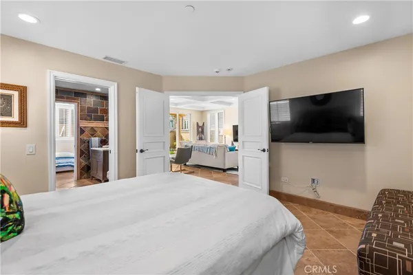 a bedroom with a bed and a flat screen tv