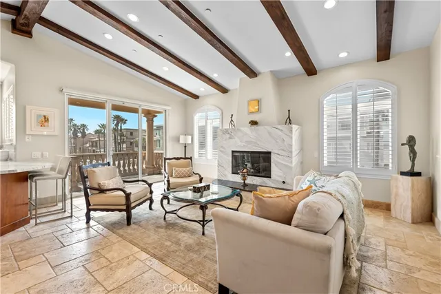 a living room with furniture a fireplace and a large window