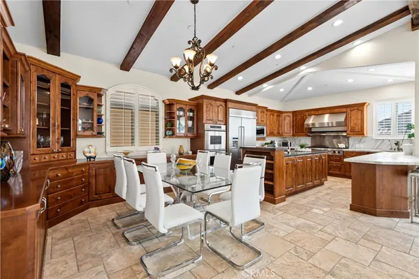 a large white kitchen with a large window and stainless steel appliances
