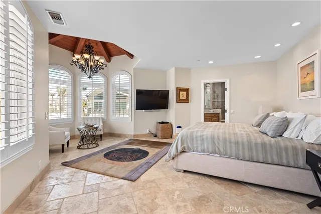 a bedroom with a bed a flat screen tv and a large window