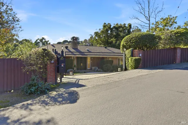 a view of a house with a yard and potted plants
