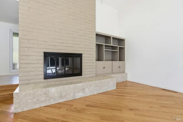 a living room with a fireplace and a wooden floor