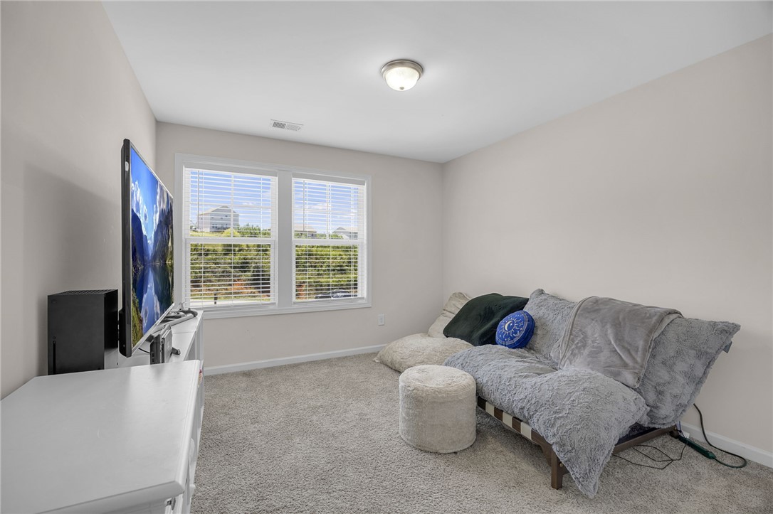430 Johnson Road Central, SC 29630 - Photo 17 of 36 A versatile secondary bedroom, well-lit by natural light from ample windows, offers plush carpeted comfort.