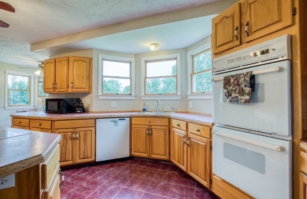 43 Tower Hill Road Brimfield, MA 01010 - Photo 13 of 36 a kitchen with stainless steel appliances granite countertop a refrigerator a sink dishwasher a stove and white countertops with wooden floor