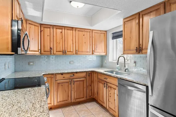 a kitchen with stainless steel appliances granite countertop a sink a stove and cabinets