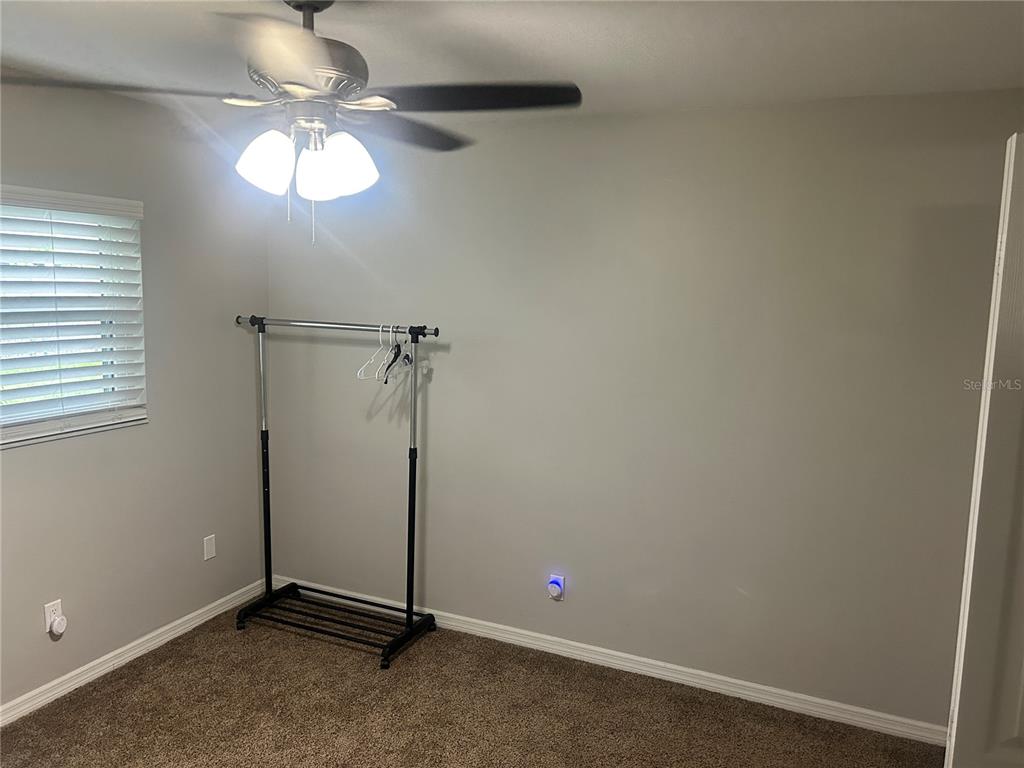 501 Firefly Lane Apollo Beach, FL 33572 - Photo 11 of 17 an empty room with a chandelier fan and a window