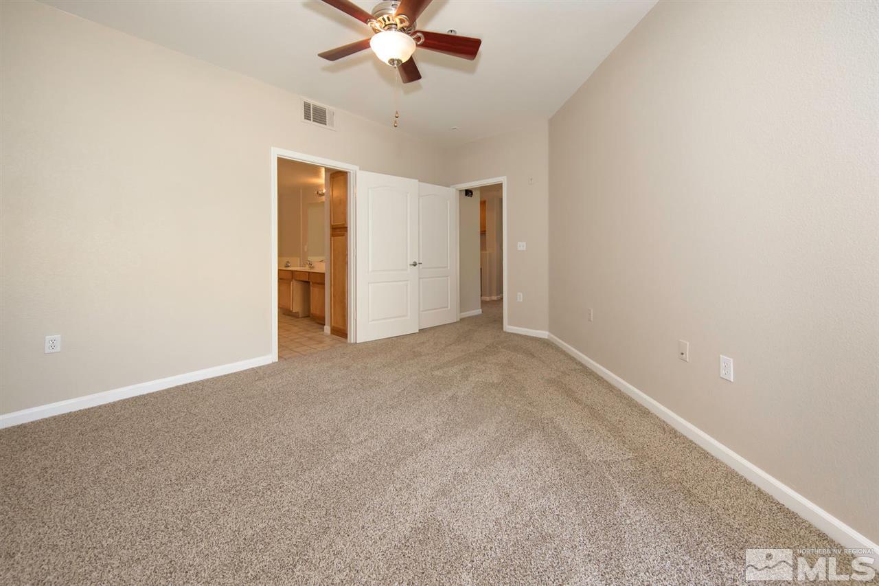 9050 Double R Boulevard, Unit 911 Reno, NV 89521 - Photo 13 of 22 an empty room with a chandelier fan and windows