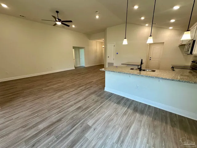 a view of a kitchen with a sink and wooden floor