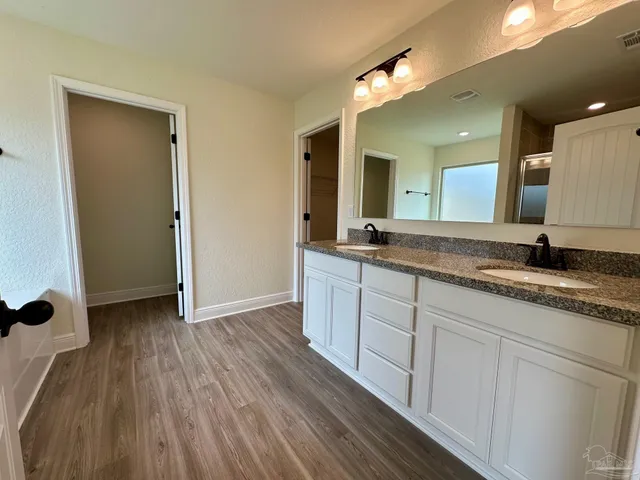 a bathroom with a granite countertop sink and a mirror