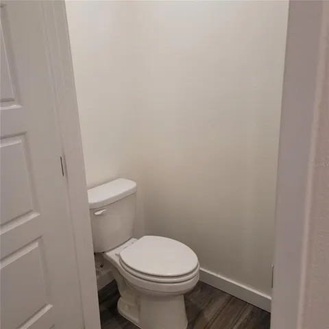 a white toilet sitting next to a white wall