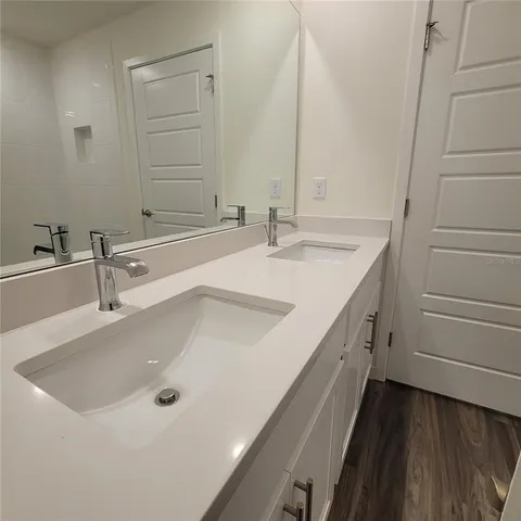 a bathroom with a double vanity sink and mirror