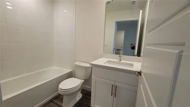 a bathroom with a sink toilet vanity and shower