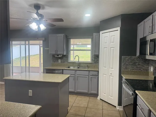 a kitchen with a sink a stove and cabinets
