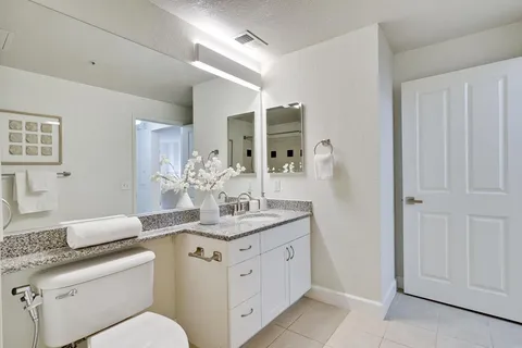 a spacious bathroom with a granite countertop sink and a mirror