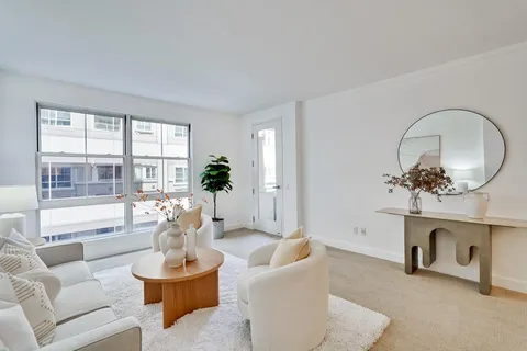 a living room with furniture a fireplace and a potted plant