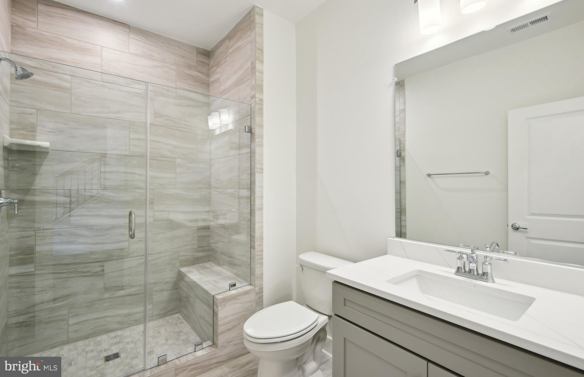 42601 Houdini Rst Terrace Leesburg, VA 20176 - Photo 33 of 52 a bathroom with a granite countertop toilet a sink a mirror and shower