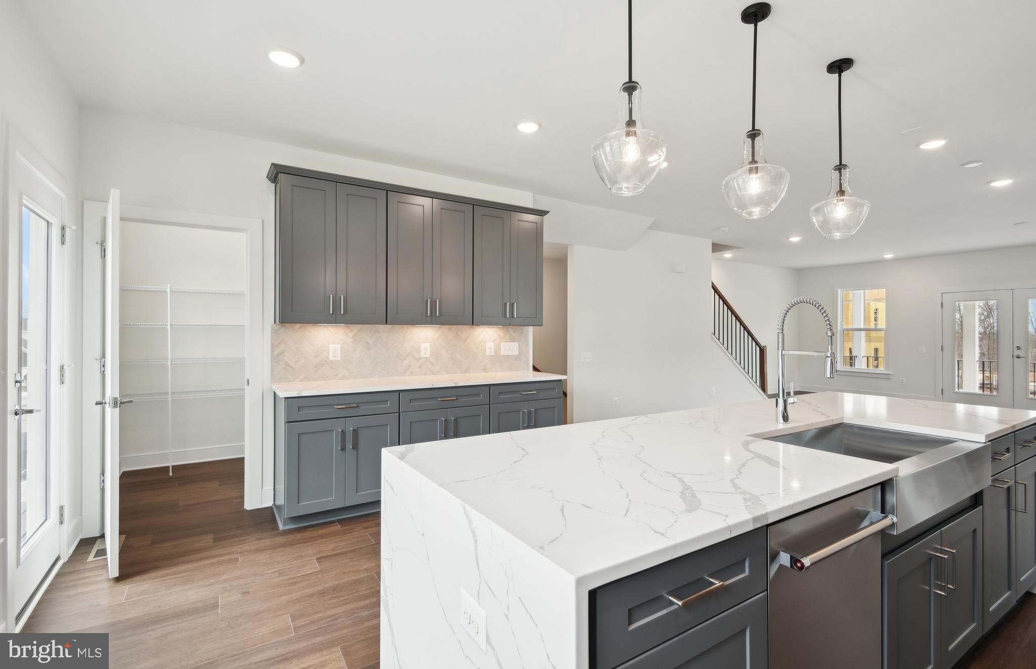 42601 Houdini Rst Terrace Leesburg, VA 20176 - Photo 5 of 52 a kitchen with center island a sink appliances and wooden floor