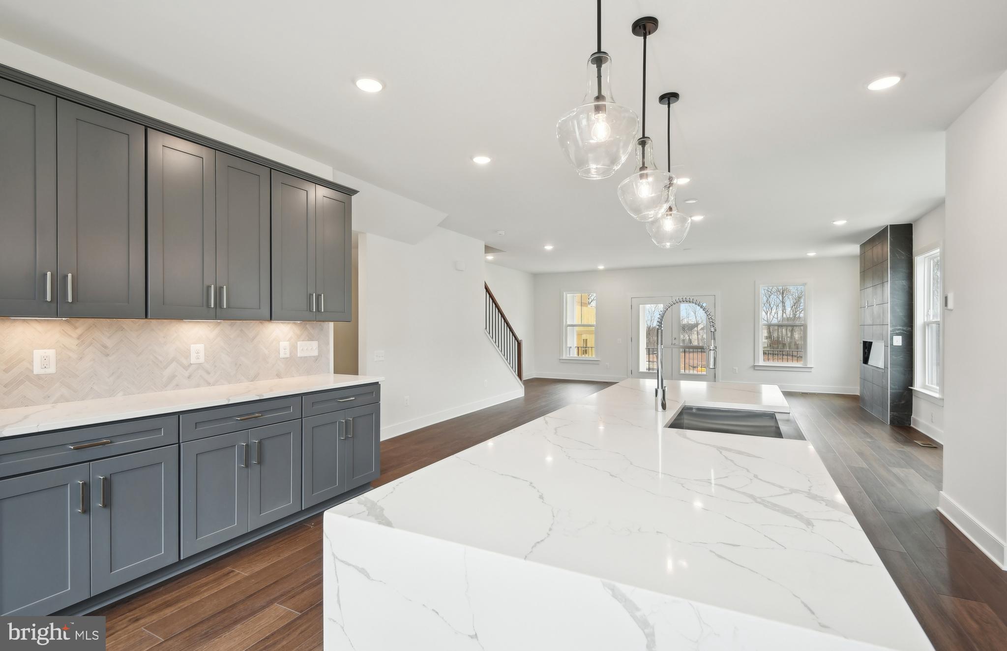 42601 Houdini Rst Terrace Leesburg, VA 20176 - Photo 8 of 52 a large white kitchen with wooden floor and a chandelier