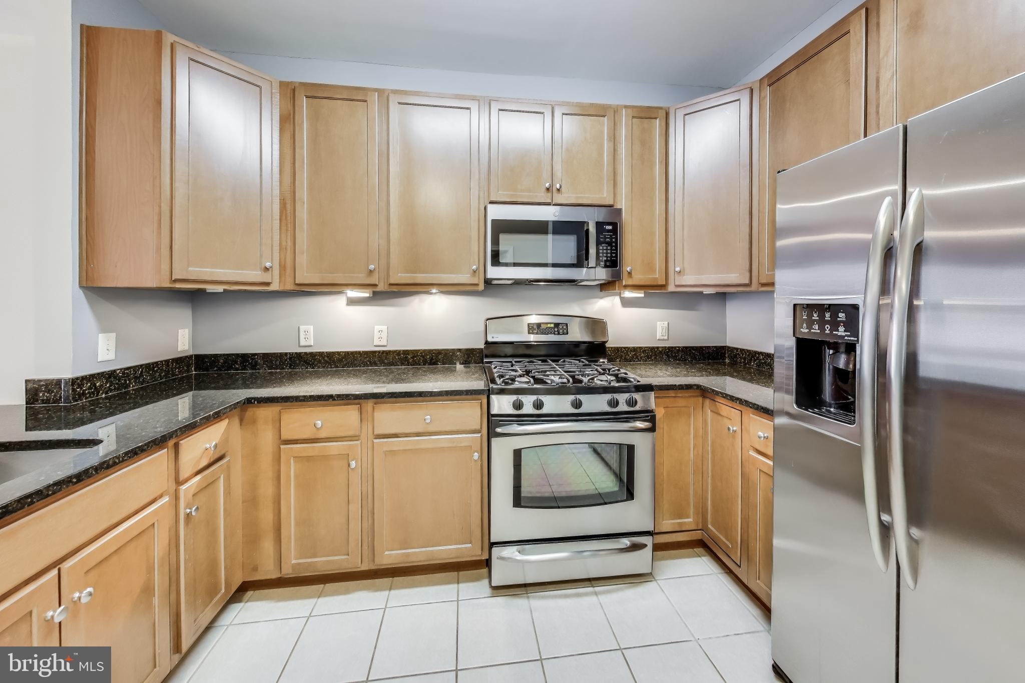 8045 Newell Street, Unit 108 Silver Spring, MD 20910 - Photo 2 of 33 a kitchen with granite countertop a sink stainless steel appliances and cabinets