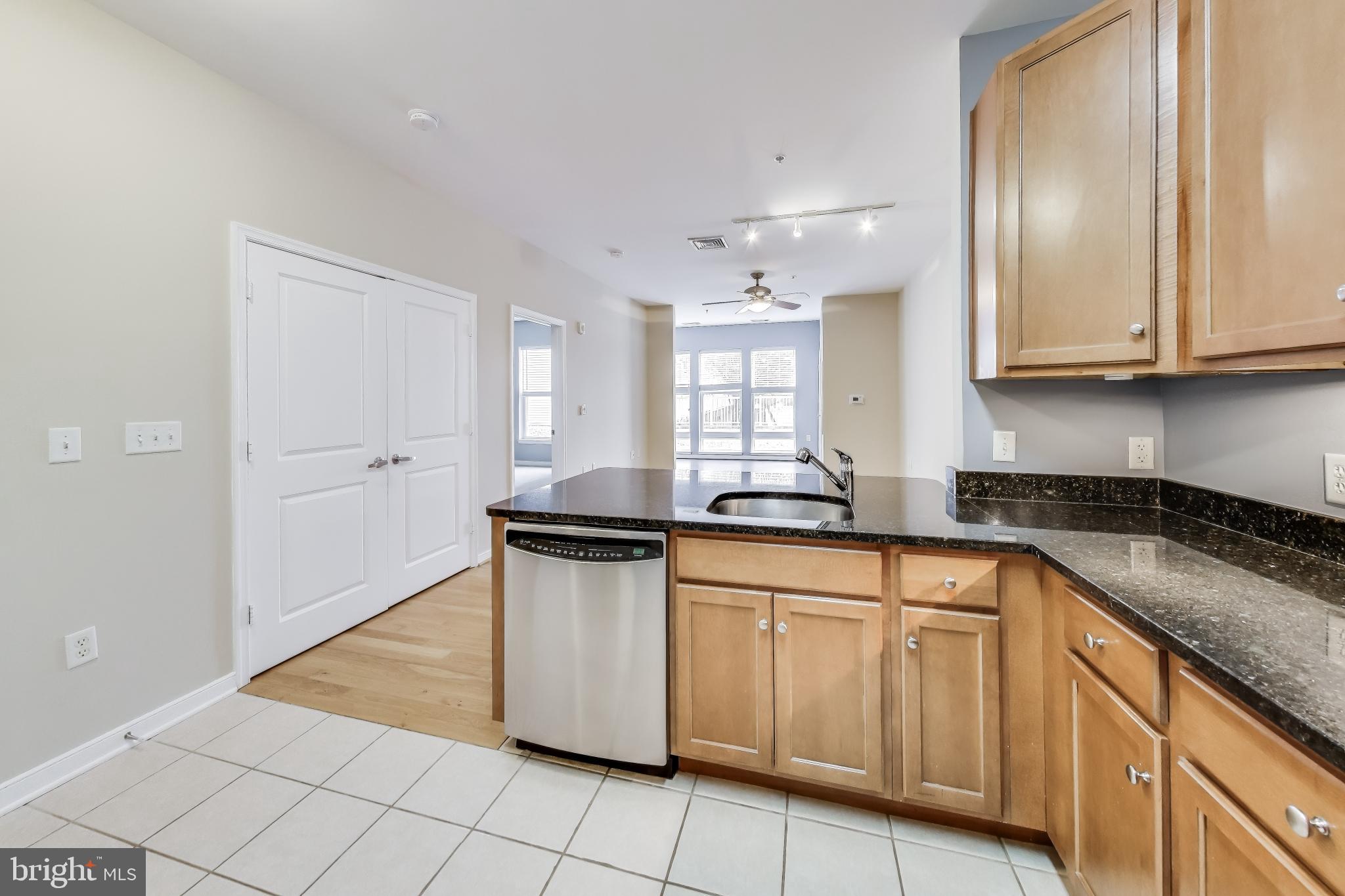 8045 Newell Street, Unit 108 Silver Spring, MD 20910 - Photo 3 of 33 a kitchen with granite countertop white cabinets and white appliances