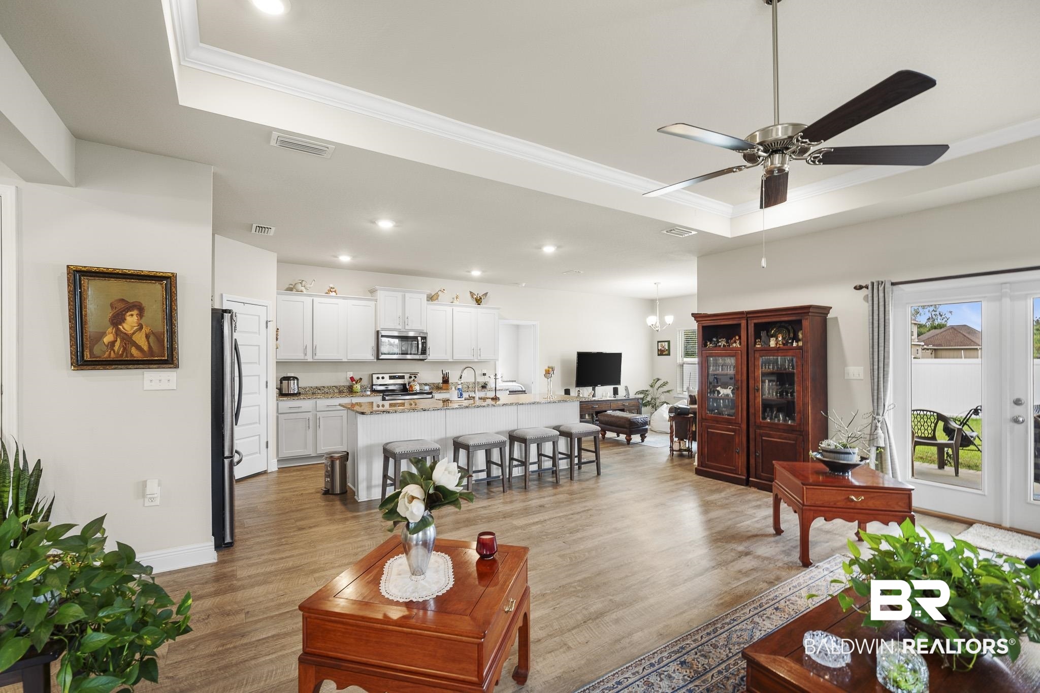 24765 Spectacular Bid Loop Daphne, AL 36526 - Photo 12 of 45 Living room featuring ornamental molding, ceiling fan, a raised ceiling, light wood-type flooring, and french doors