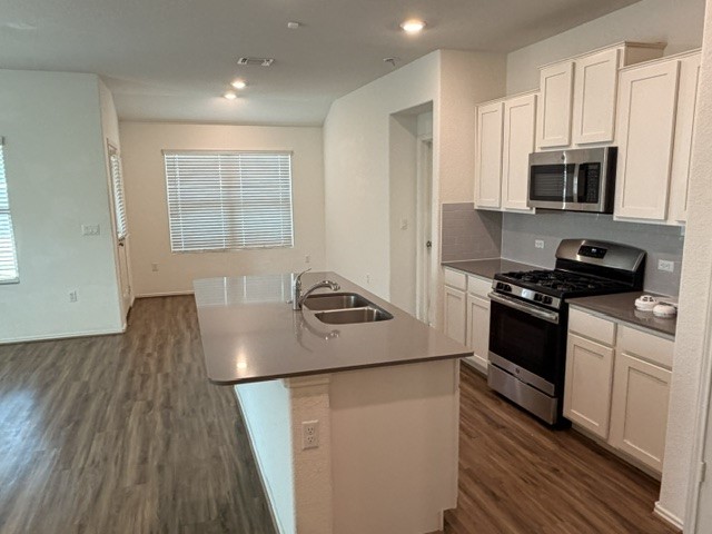 6917 Colorado Bluffs Road Austin, TX 78744 - Photo 4 of 19 a kitchen with stainless steel appliances granite countertop a stove a sink and a microwave