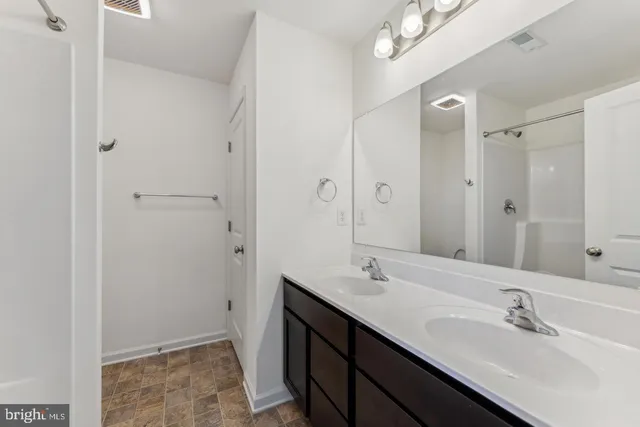 a bathroom with a double vanity sink a and mirror