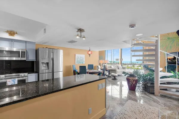 a kitchen with stainless steel appliances kitchen island granite countertop a refrigerator and a stove