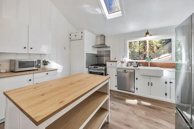 a kitchen with a stove a sink and a window