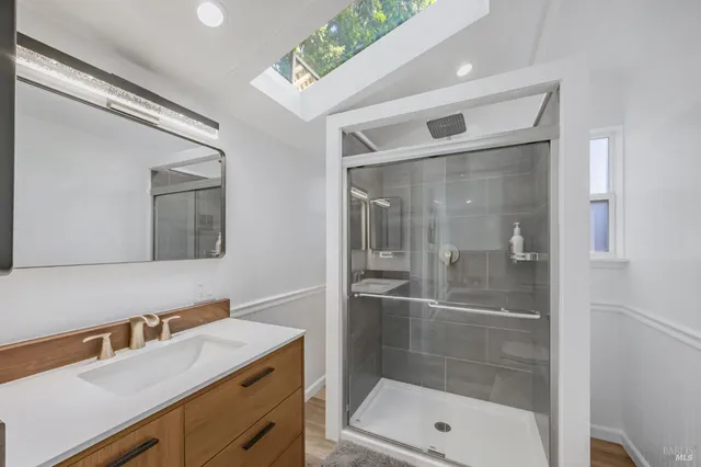 a bathroom with a shower sink and mirror