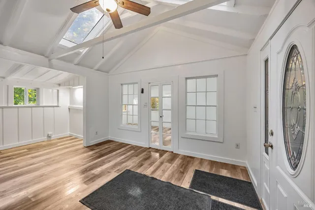 a view of an empty room with window and bathroom