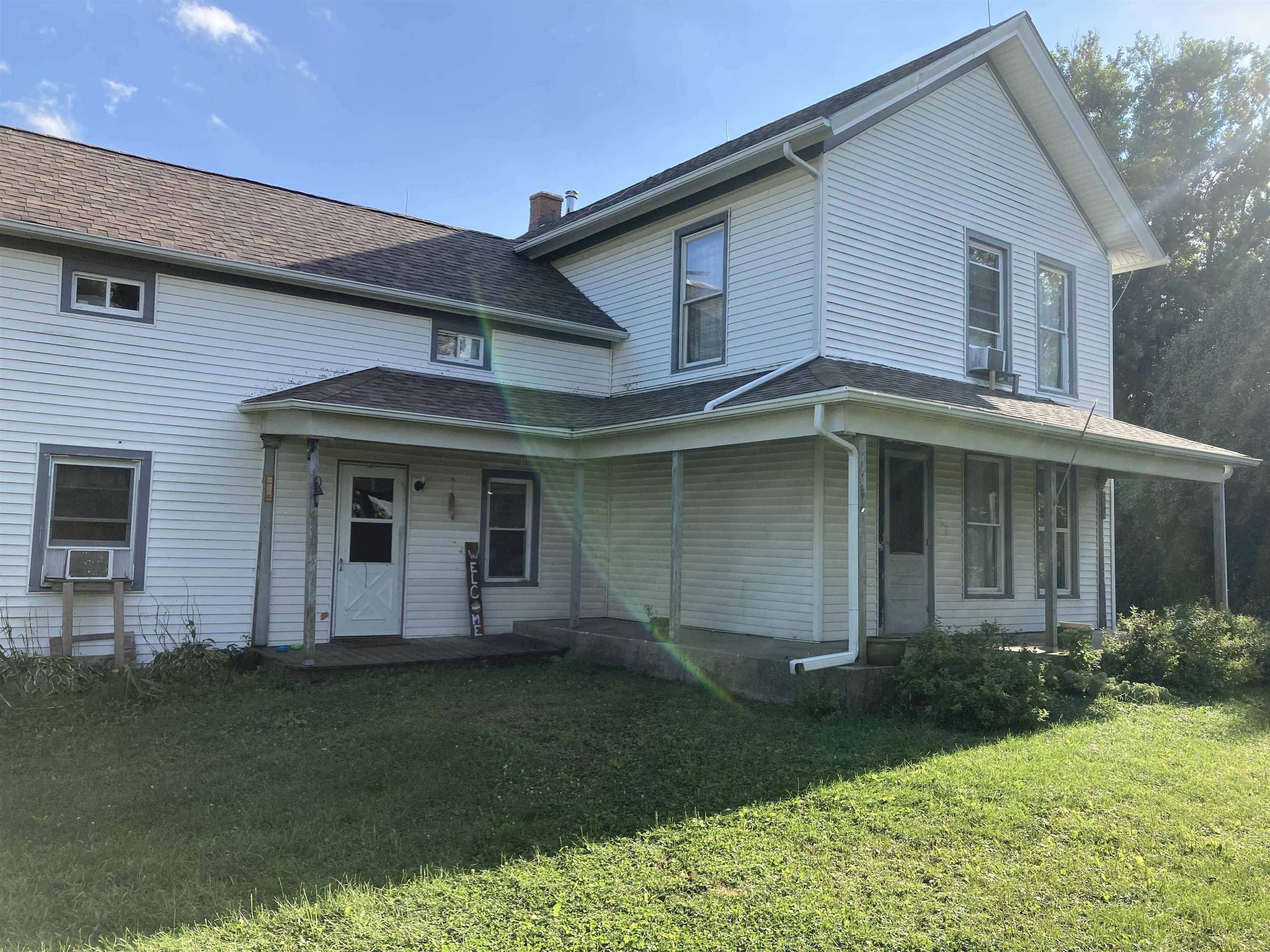15702 Farm School Road Durand, IL 61024 - Photo 4 of 38 a view of a white house with a big yard and potted plants