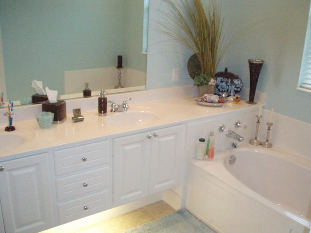 263 Caravelle Drive Jupiter, FL 33458 - Photo 8 of 14 a bathroom with a bathtub sink and mirror