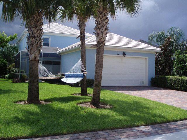 263 Caravelle Drive Jupiter, FL 33458 - Photo 9 of 14 a front view of house with a garden