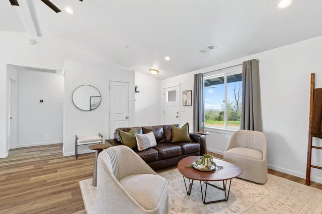 a living room with furniture a rug and a window