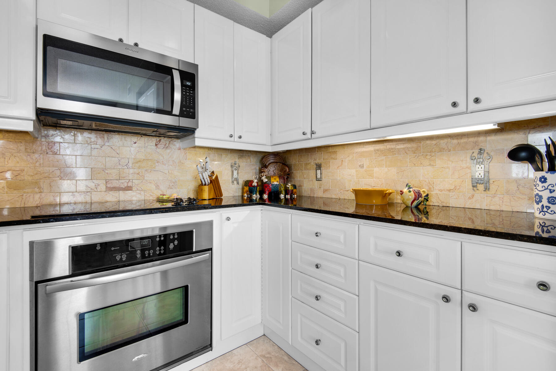 8501 Gulf Boulevard, Unit WPH3A Navarre, FL 32566 - Photo 17 of 66 a kitchen with granite countertop white cabinets stainless steel appliances and wooden floor