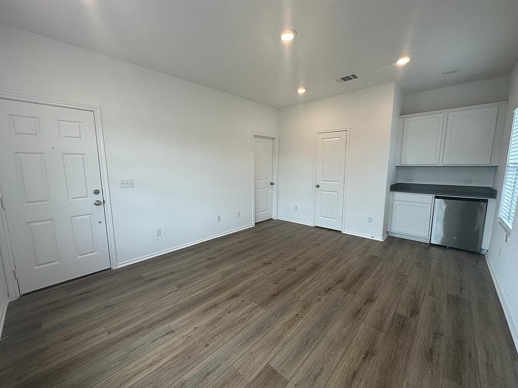 160 River Rise Road Kyle, TX 78640 - Photo 26 of 35 Spacious interior featuring wood-finish flooring, recessed lighting, and a built-in cabinetry unit with a stainless steel appliance