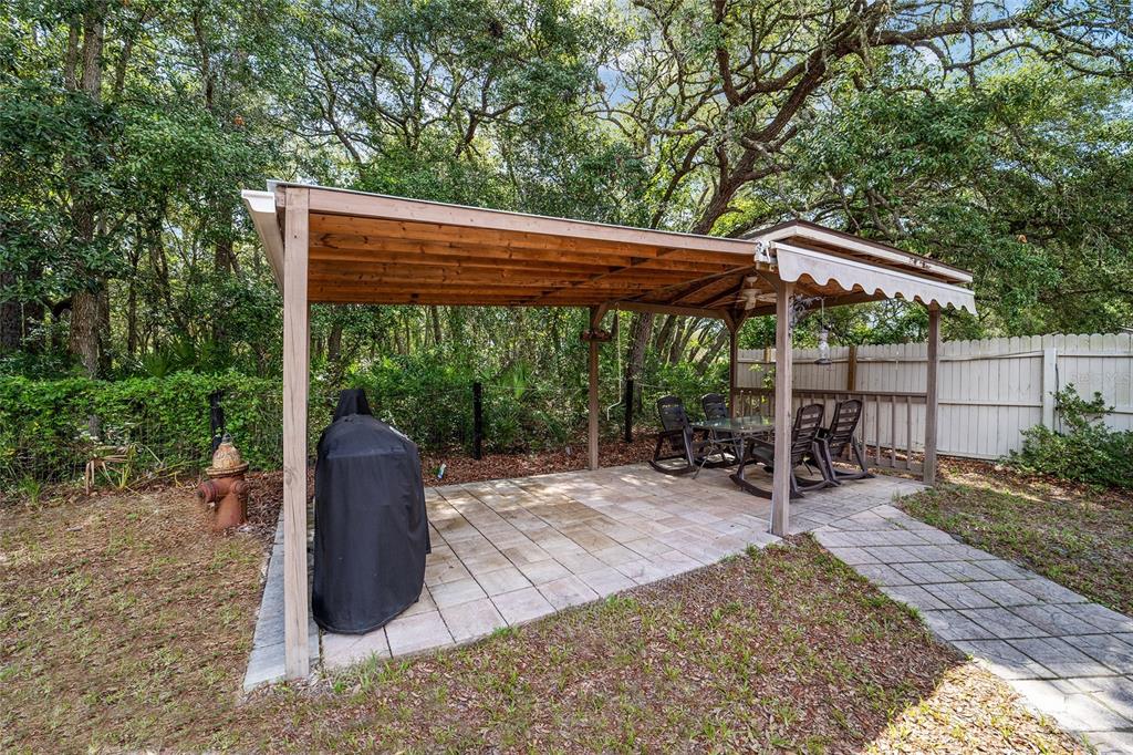 15755 Southwest 90th Avenue Dunnellon, FL 34432 - Photo 39 of 55 a backyard of a house with table and chairs under an umbrella