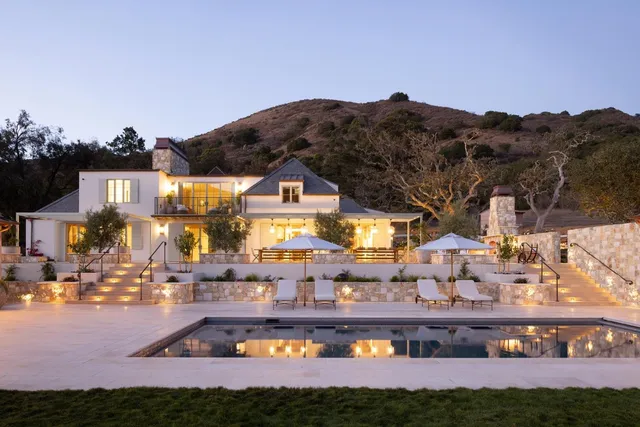 a view of a patio with a table and chairs under an umbrella