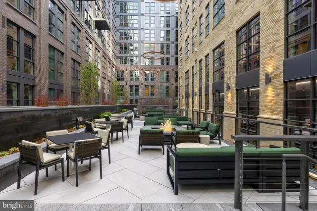 a view of a patio with table and chairs and barbeque grill